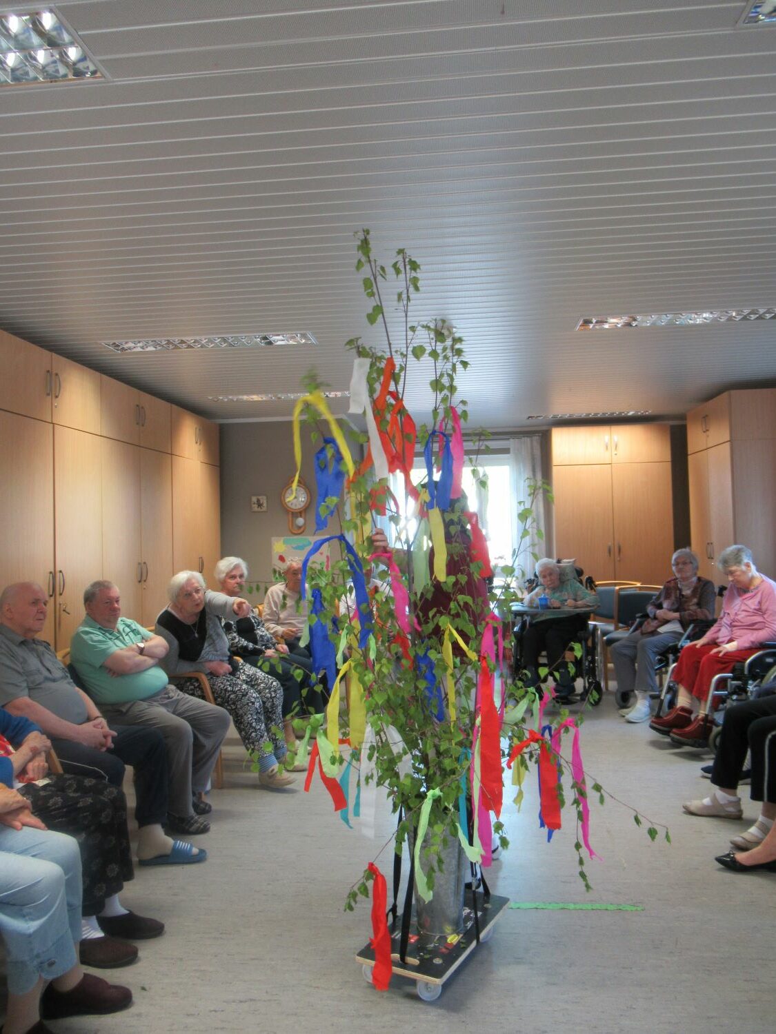 Bewohner*innen betrachten den Maibaum