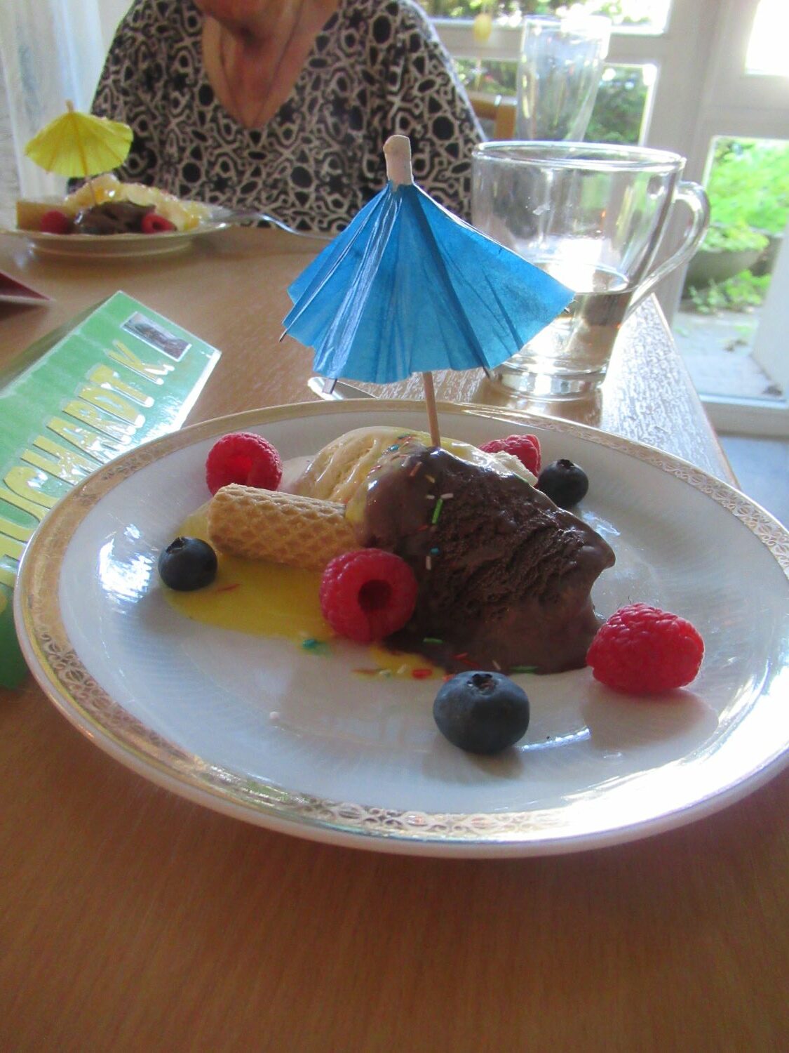 ein Schokoeis mit Obst und einem Sonnenschirm geschmückt