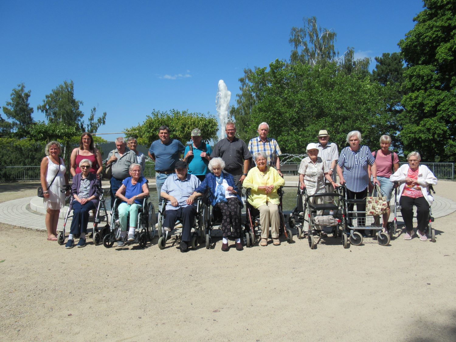 Gruppenfoto der Bewohner*innen vor dem Springbrunnen